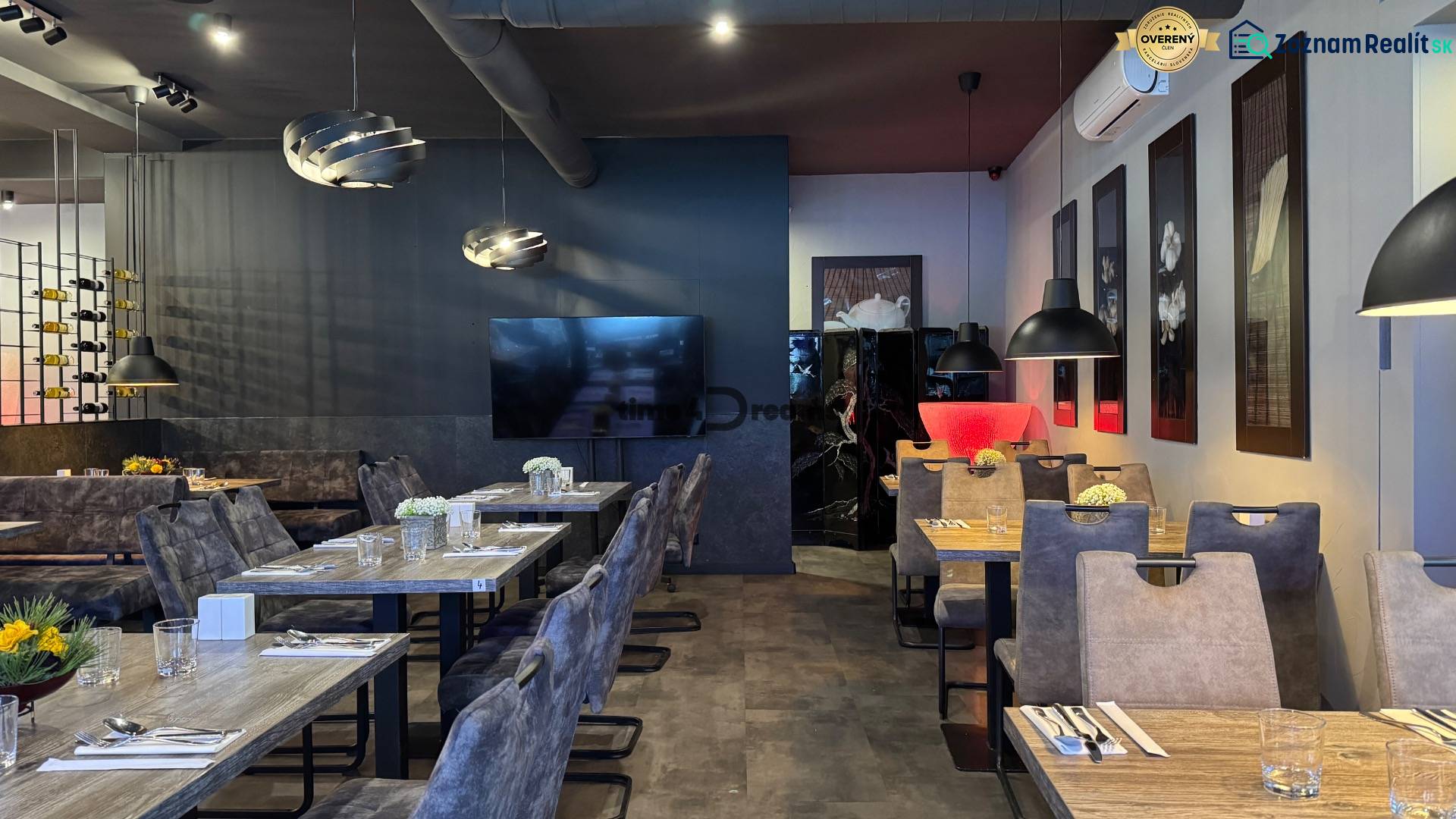 ODSTÚPENIE Gastro prevádzky na Námestí v Nitre - Interiér s podlahou s dreveným dekorom, dekoratívne lustre, elegantné sedenie v gastro priestoroch.