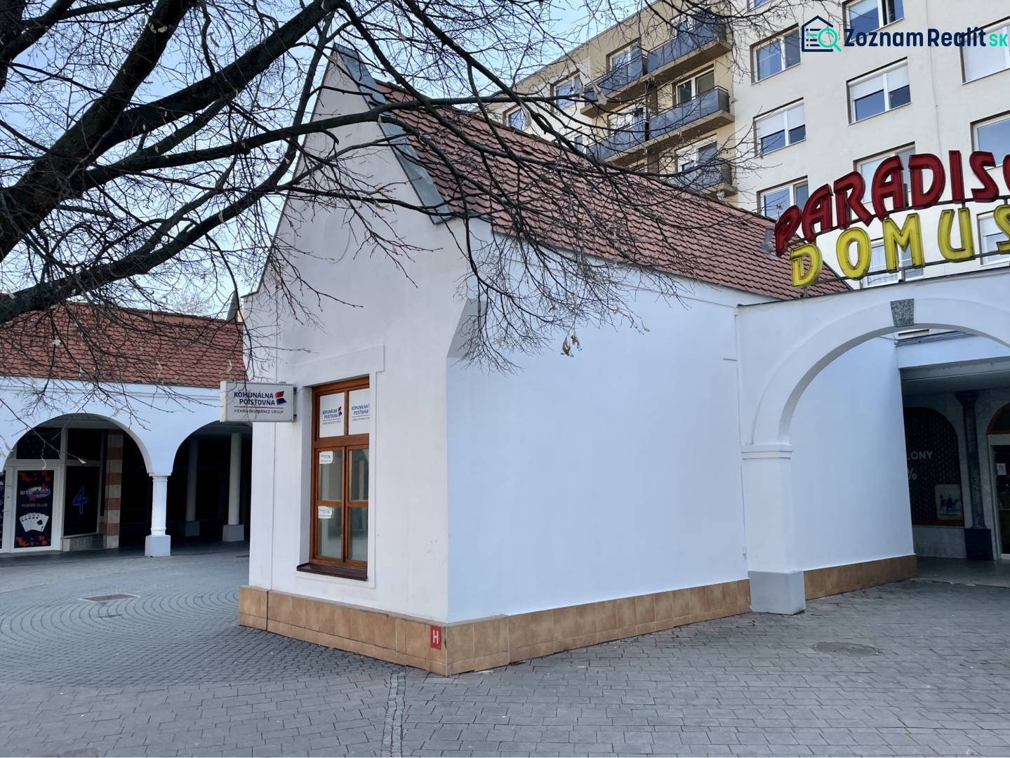 DUNASJKÁ STREDA – OBCHODNÝ PRIESTOR PRIAMO V CENTRE MESTA - Budova s oblúkmi a nápisom na Námestí Ármina Vámbéryho v Dunajskej Strede.