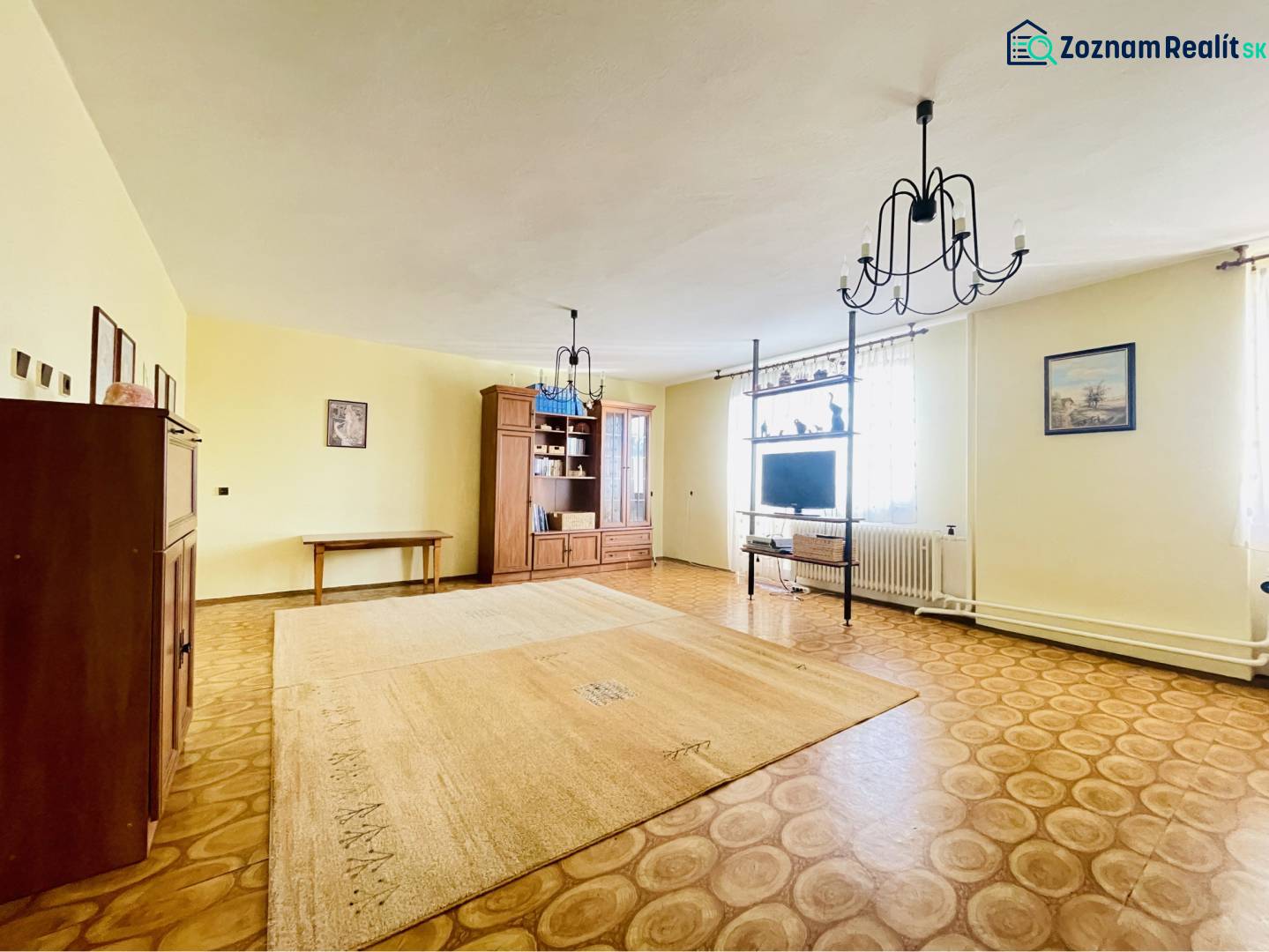 A-W REAL | POSCHODOVÝ DVOJDOM S GARÁŽOU NA PREDAJ V OBCI BÚČ - Obývacia izba v rodinnom dome s podlahou s dreveným dekorom a elegantnými svietidlami.