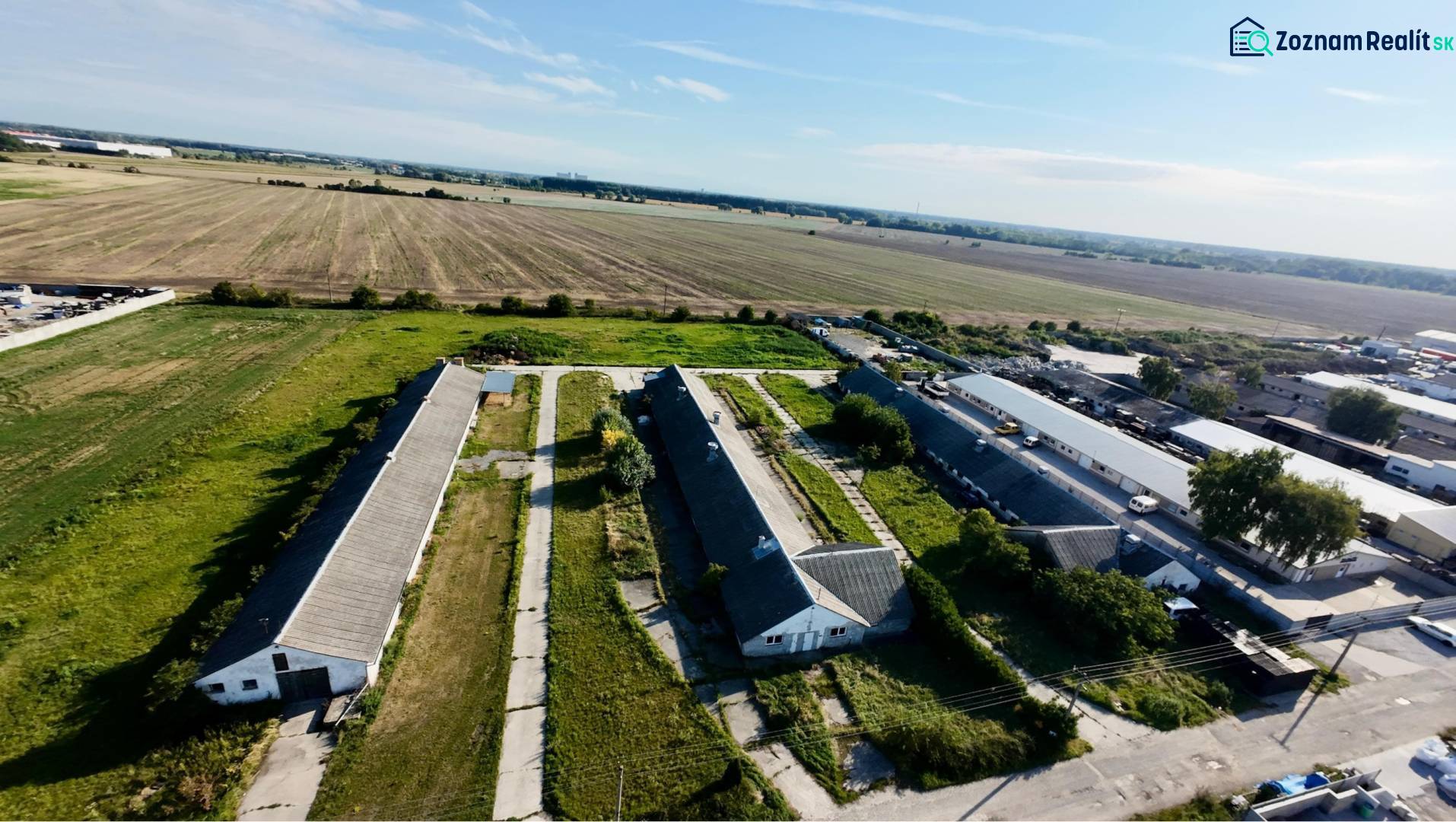 Kostolné Kračany - skladové - prevádzkové priestory na predaj za cenu  - Letecký pohľad na výrobné priestory na Amadeho Kračany v Kostolnom Kračanoch obklopené poľami.