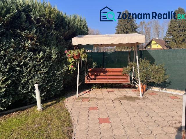 Rodinný  dom na predaj v Gabčíkove - Záhrada rodinného domu s hojdačkou, chodníkom a bujnou zeleňou v pozadí.