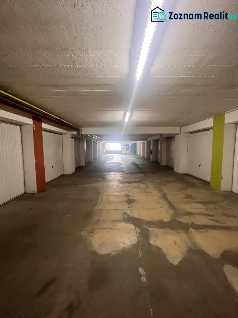 Garáž na prenájom. - Interiér garáží s osvetlením a betónovou podlahou.
