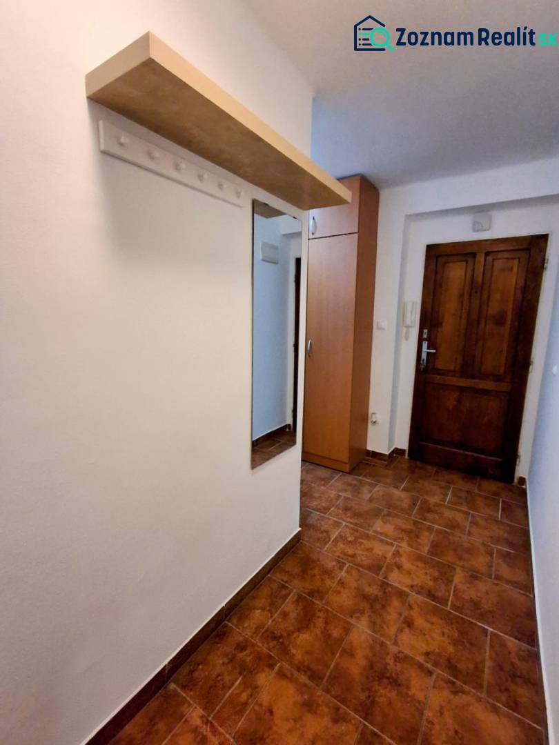 ☎️   0918 846 340           Byt v centre mesta na Jesenského ulici. - Chodba v 1-izbovom byte s vešiakovou stenou a dlažbou v teplých tónoch.