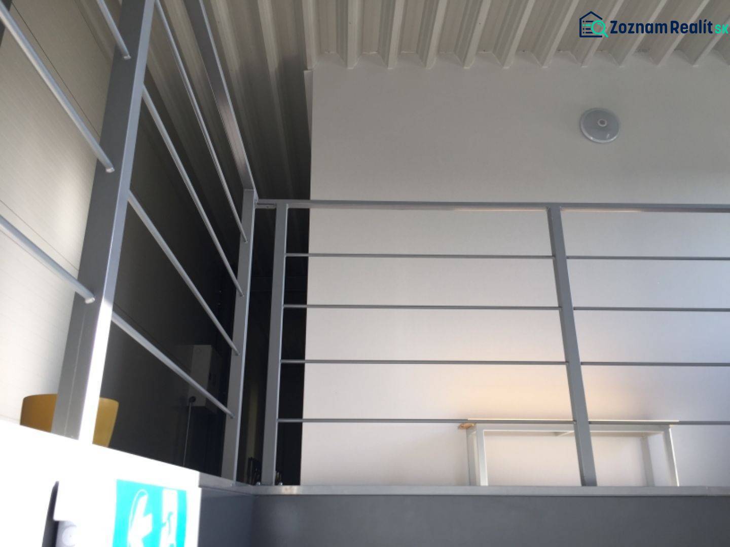 Kancelárský priestor 37,5 m2 na prenájom oproti OD TESCO v Dunajskej S - Kovové zábradlie v kancelárii na ulici Hlavná s bielymi stenami a svetlom.