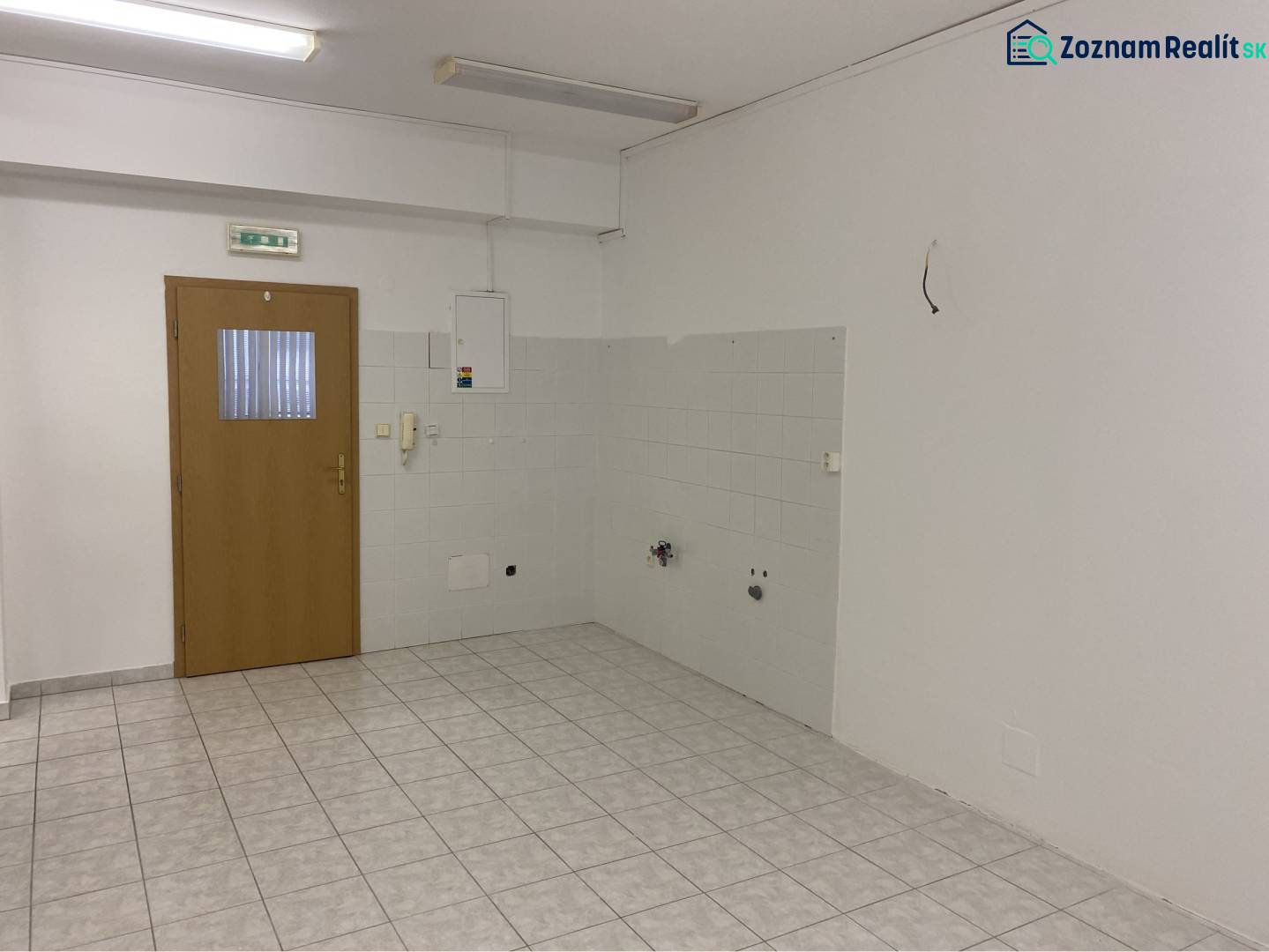 Skvelá ponuka!!! Prenájom nebytového priestoru na podnikateľské účely  - Interiér budovy s keramickou dlažbou, drevenými dverami a svetlými stenami.