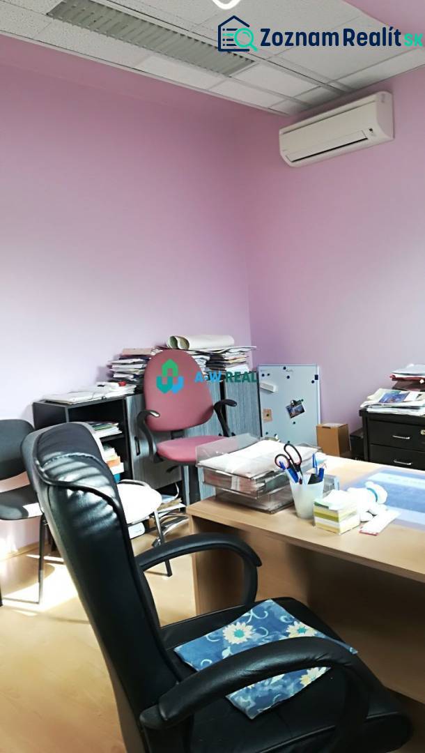 Kancelársky priestor s klimatizáciou na prenájom - Kancelária s ružovými stenami, stoličkami a stolom, na ulici neuvedené.