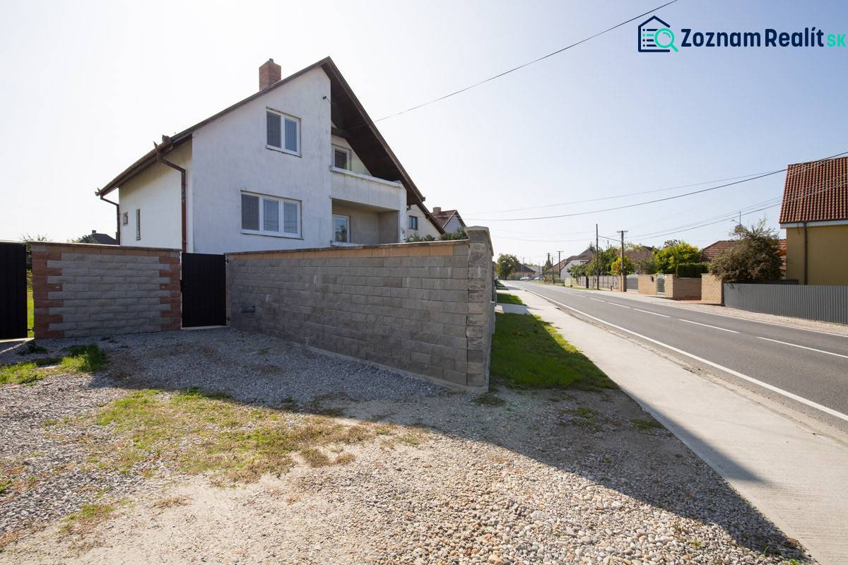 Dvojpodlažný rodinný dom s veľkým pozemkom na predaj v obci Jahodná - Rodinný dom, na ulici neuvedená, s kamenným plotom vedľa cesty a dvora.