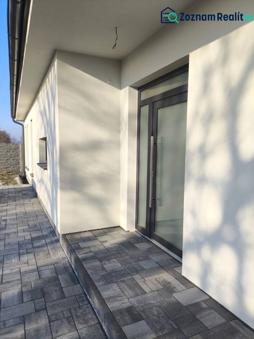 4 izbový rodinný  dom v obci Michal na Ostrove! - Vstup do rodinného domu v Michale na Ostrove s dlažbou a sklenenými dverami.