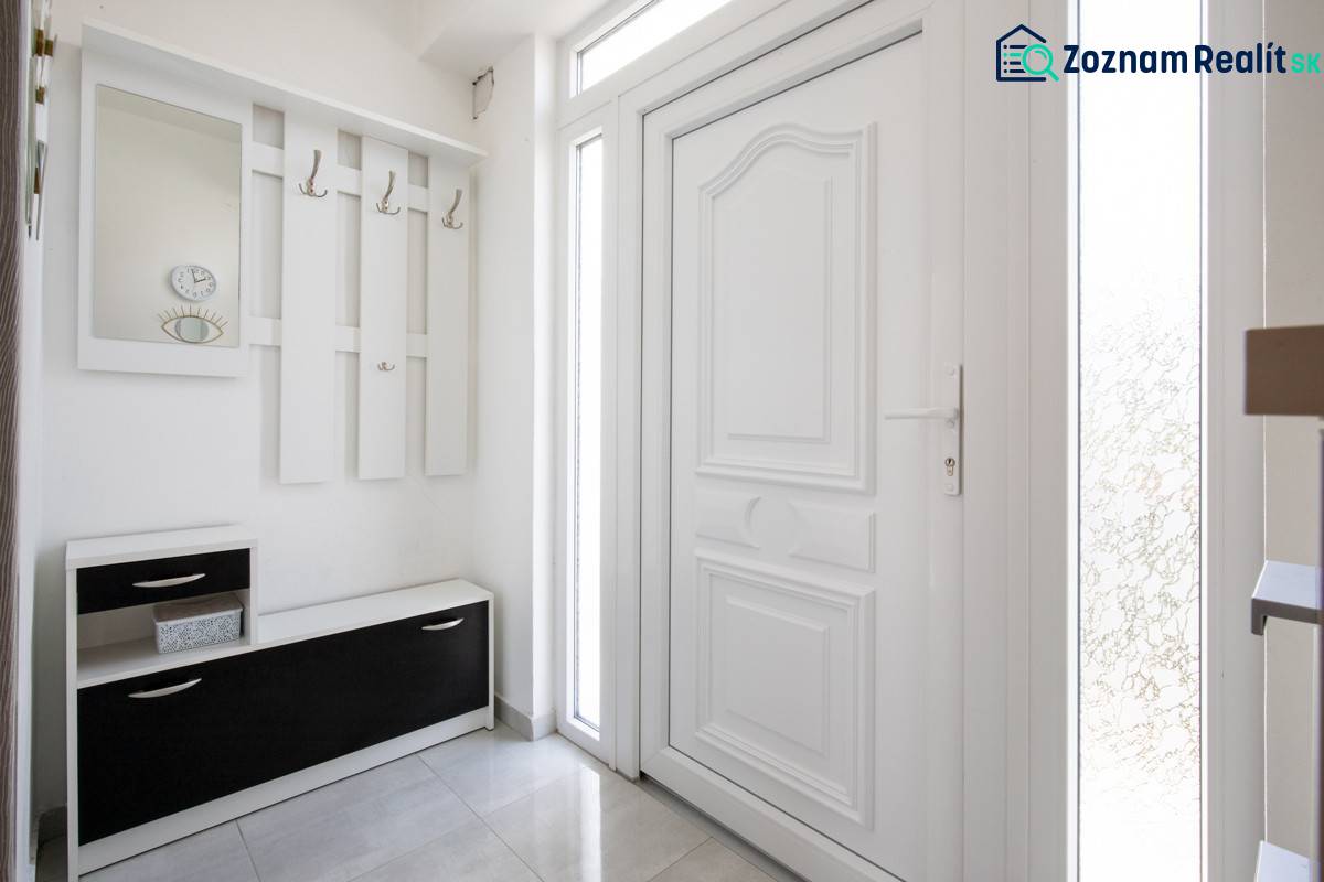 Znížená cena za 4 izbový rodinný dom v obci Jahodná - Vstupná hala rodinného domu s vešiakom, zrkadlom, nábytkom a bielymi dverami.