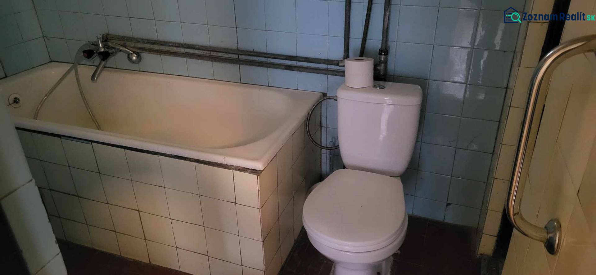 Na predaj starší rodinný dom v obci Ohrady - Kúpeľňa v rodinnom dome s vaňou, toaletou a modrými obkladačkami.