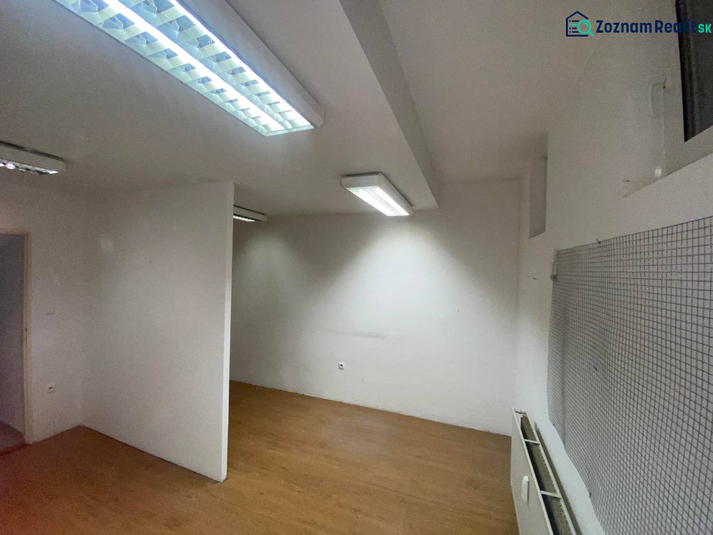 ☎️ 0918197701-Na prenájom menší priestor v suteréne  v srdci  mesta Du - Kancelárie s bielymi stenami a podlahou s dreveným dekorom, osvetlené žiarivkami.