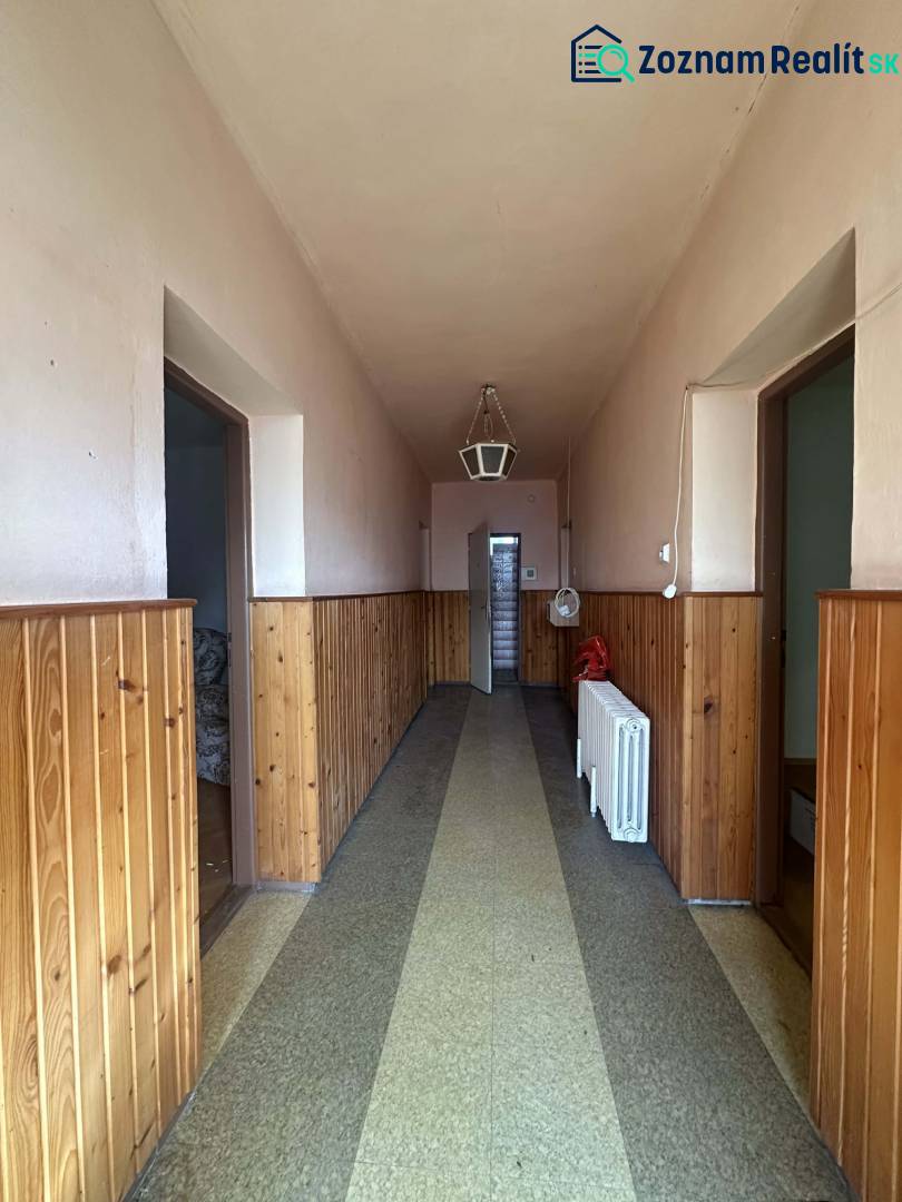 ☎️0918197701 Rodinný dom s veľkým potenciálom v obci Dolný Štál – ideá - Úzky chodba v rodinnom dome s dreveným obkladom a lampou na strope.
