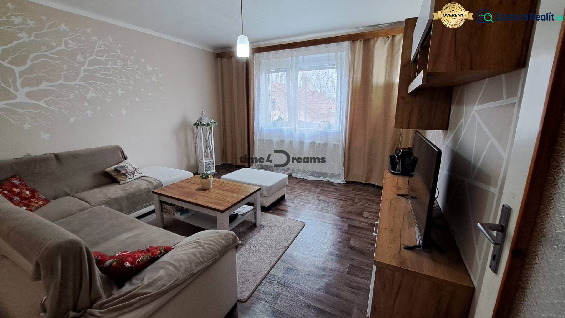 NA PREDAJ 6 izbový rodinný dom v obci Hrušovany  - Obývacia izba v rodinnom dome s podlahou s dreveným dekorom a pohodlnou pohovkou.