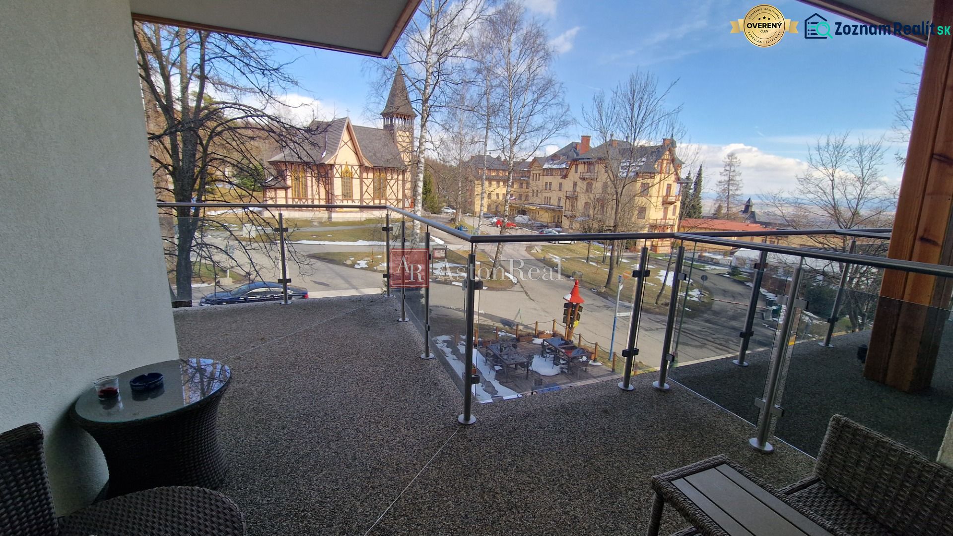 Rekreačný apartmán Vys. Tatry- HREBIENOK RESORT I. - 92 m2 -3-izbový - Balkón rekreačného apartmánu s výhľadom na kostol a architektúru v Starom Smokovci, Vysoké Tatry.