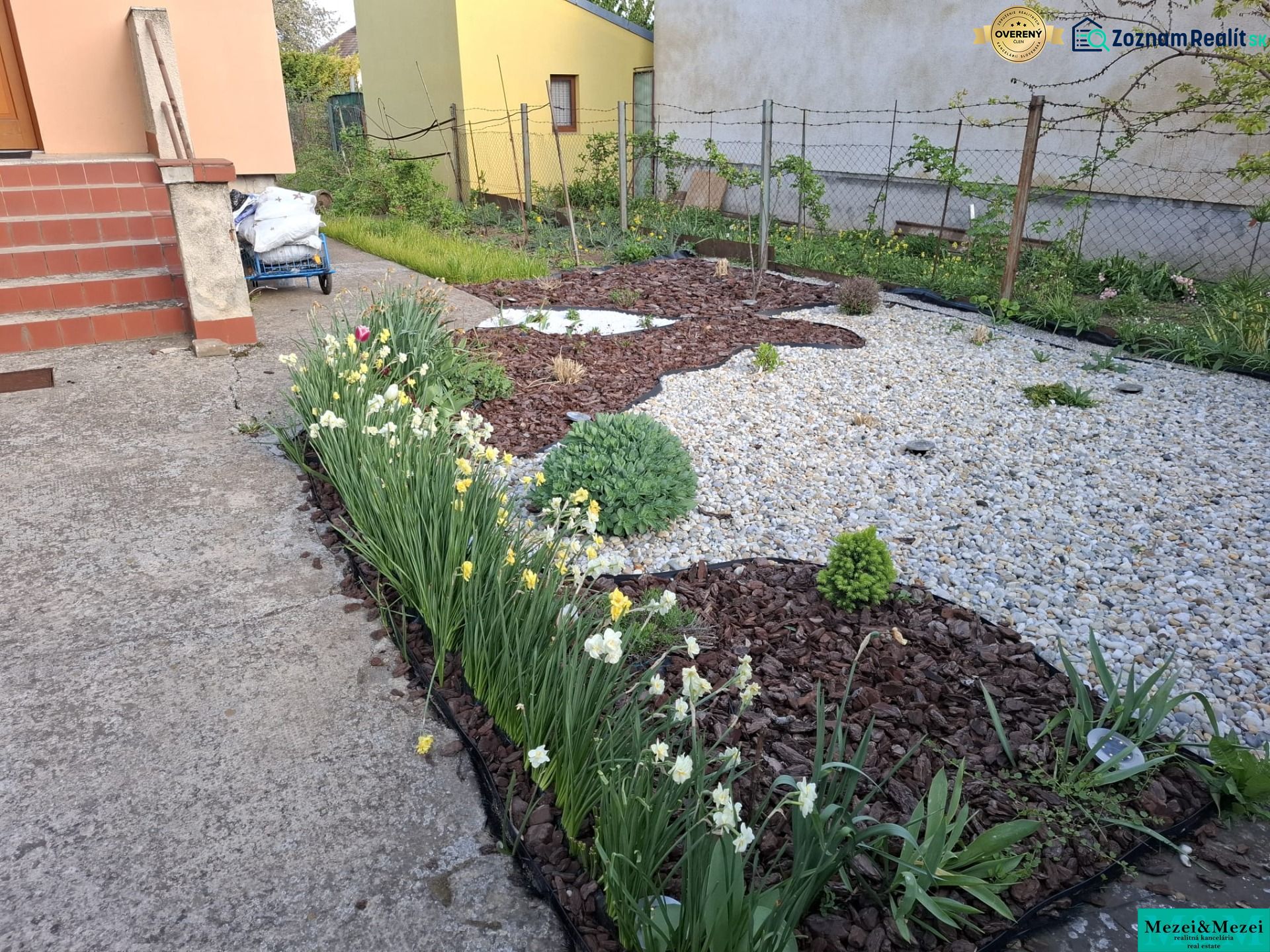 Komfortný dom pre celú rodinu - Záhrada rodinného domu v Trnave s kvetinovými záhonmi a štrkovým povrchom.