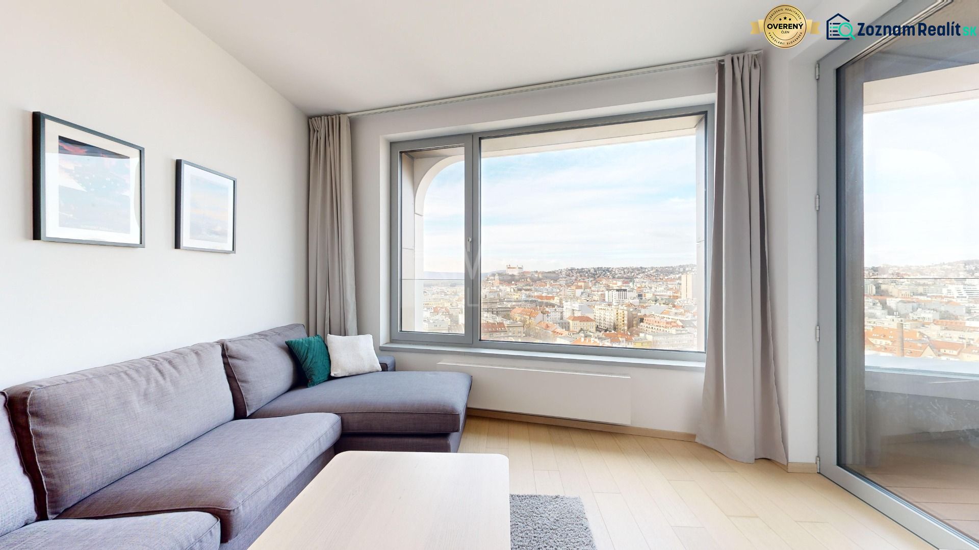 Byt v minimalistickom štýle s výhľadom na hrad - Na ulici Čulenova, 2-izbový byt s panoramatickým výhľadom, pohodlná sedačka, obrazy na stene.