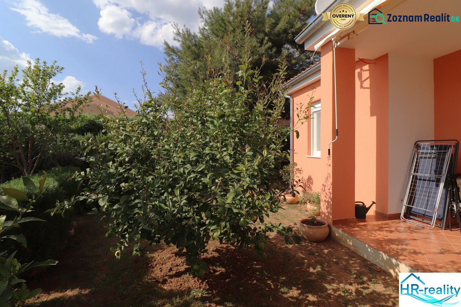 Chorvátsko, Vodice - zariadený bungalov, výhľad na more - Rodinný dom vo Vodiciach s oranžovou fasádou a upravenou záhradou.
