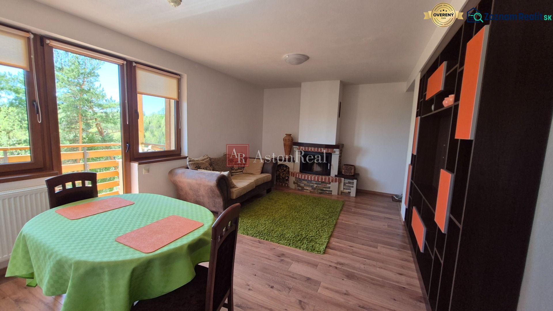Investičný apartmán Vysoké Tatry - Stará Lesná s balkónom a park.miest - Obývačka v rekreačnom apartmáne s krbom, pohovkou a výhľadom cez veľké okná.