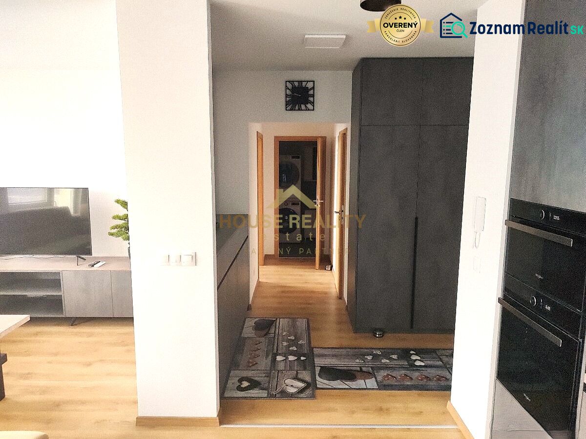 Prenájom 2 izb. byt NOVOSTAVBA, Ivanská cesta, Bratislava II. Ružinov - Interiér 2-izbového bytu s podlahou s dreveným dekorom, televíziou a úložným priestorom.