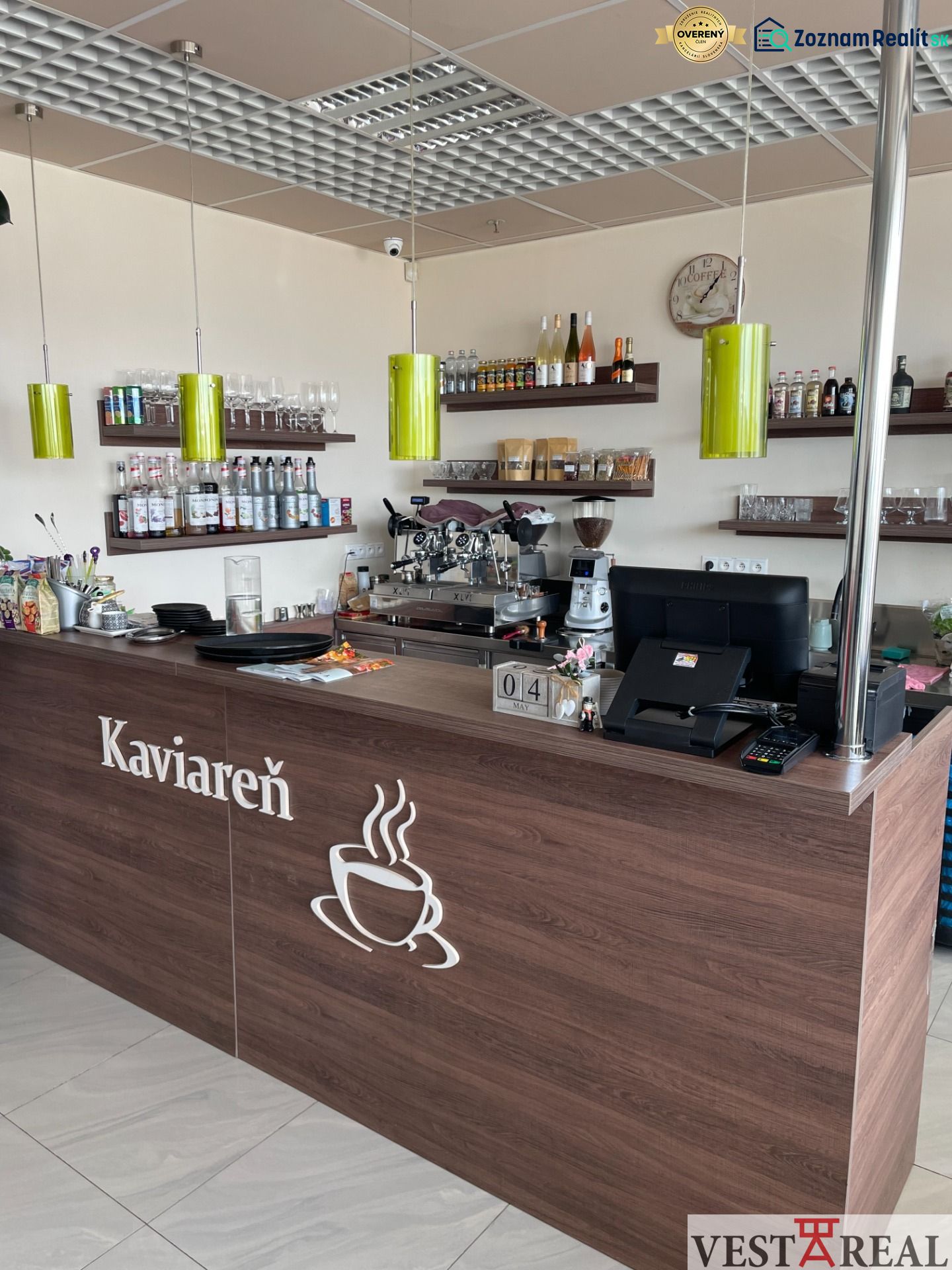 ODSTÚPENIE ZABEHNUTEJ KAVIARNE V CENTRE TRNAVY – TROJIČNÉ NÁMESTIE - Interiér kaviarne s dreveným dekorom, pultom, poličkami a kávovarom, optimalizovaný na gastro priestory.