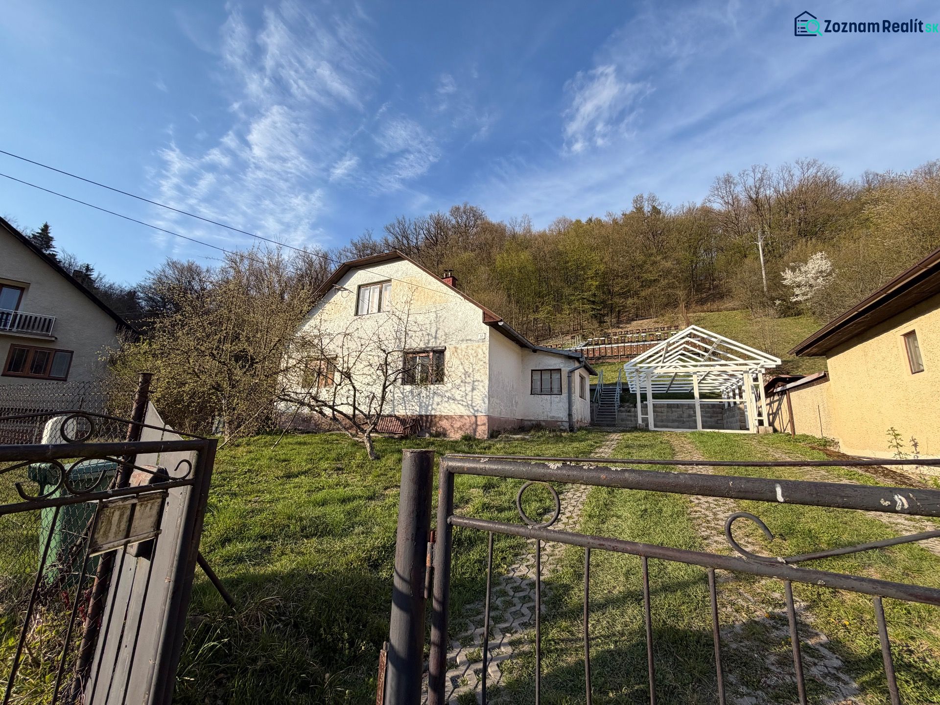 RODINNÝ DOM V PRÍRODE - NA PREDAJ -OBEC ŠTÓS  - Rodinný dom v Štóse s prístreškom na dvore, zelený trávnik, obklopený prírodou.