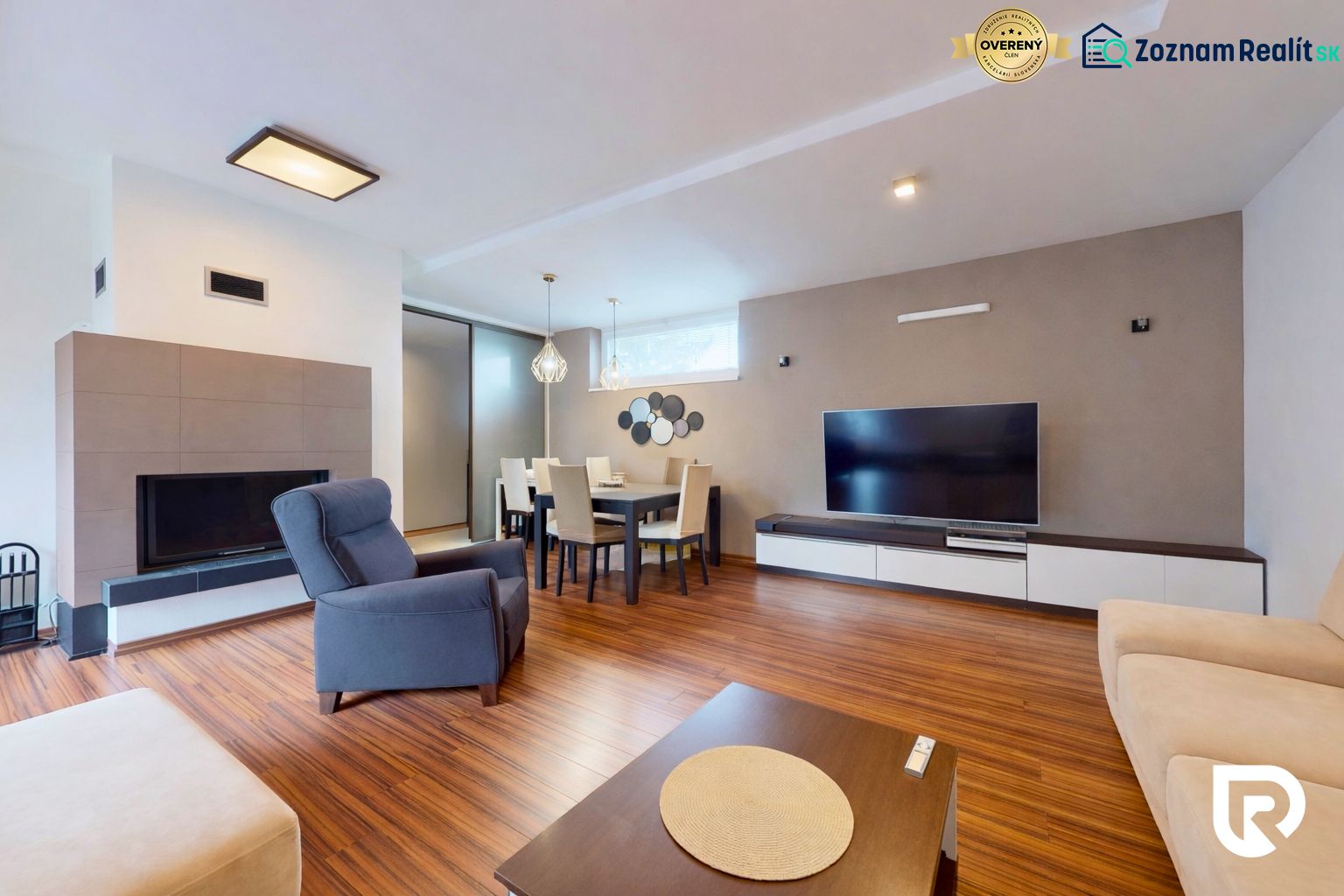 5-izbový dom 170m² + pozemok 529m² | Podunajské Biskupice - Obývačka s krbom, TV, kreslom a podlahou s dreveným dekorom v rodinnom dome.