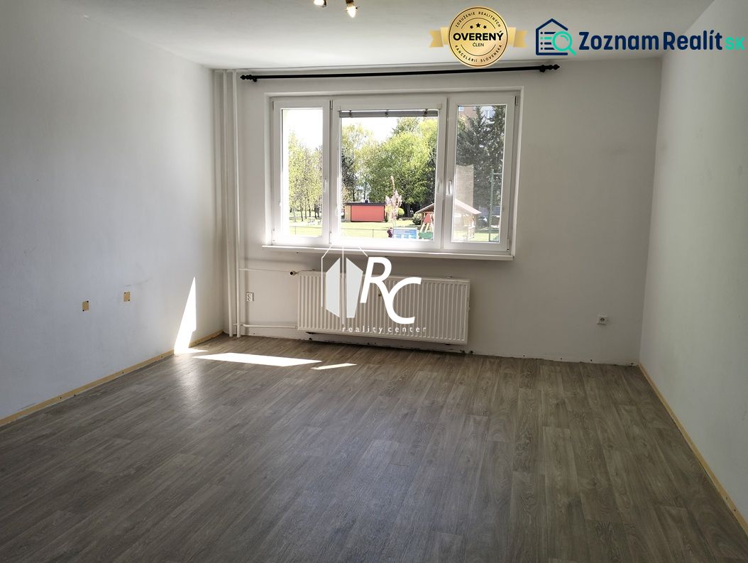 3-izbový byt s možnosťou zmeny na 4-izbový, Martin - Záturčie - Prázdny svetlý interiér s veľkým oknom a podlahou s dreveným dekorom v 3-izbovom byte.