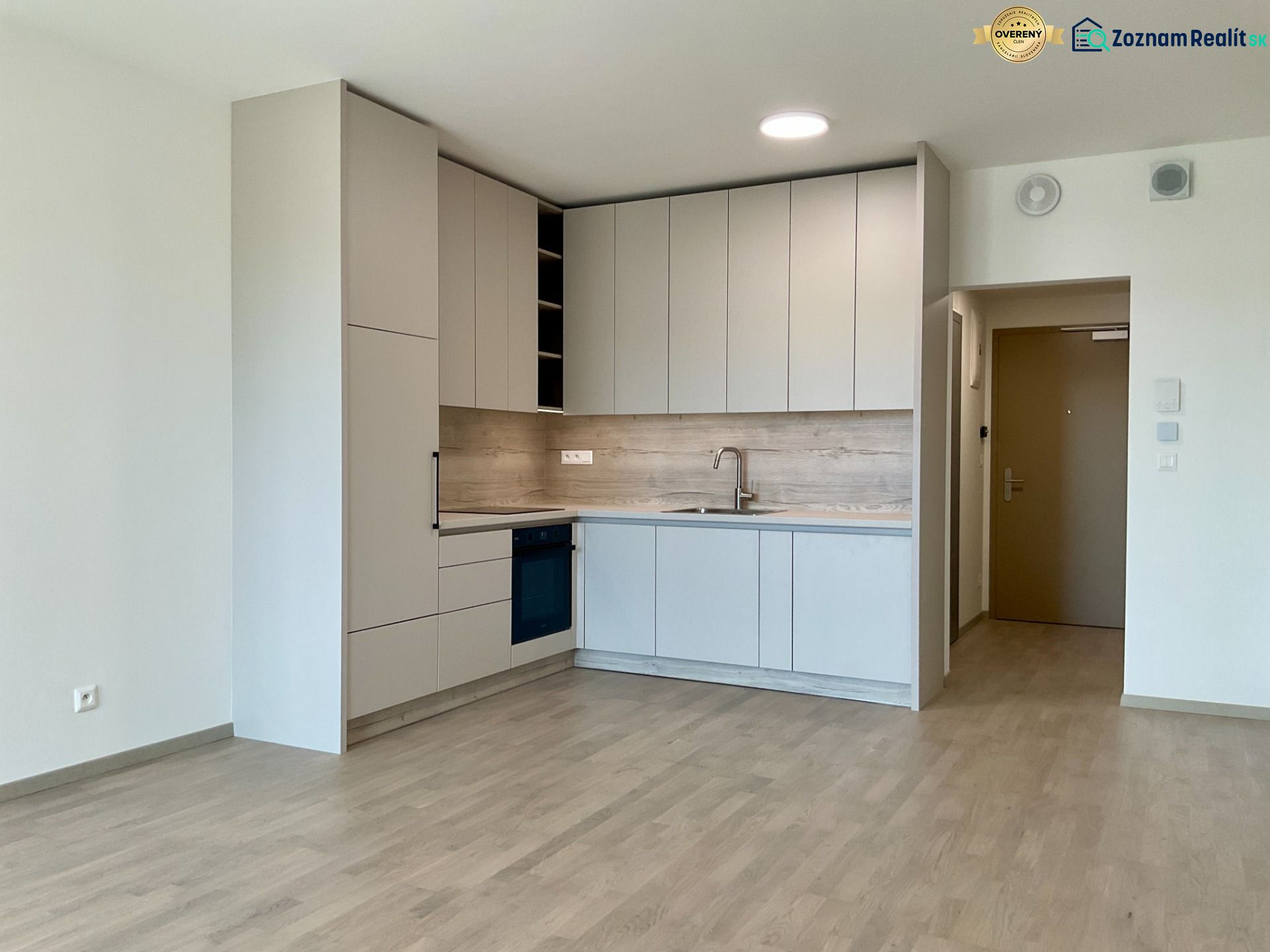 I Predaj Výnimočný  1-izb apartmán v projekte Metropolis - Moderná kuchyňa v 1-izbovom byte, svetlé skrinky, podlaha s dreveným dekorom, neutrálny štýl.