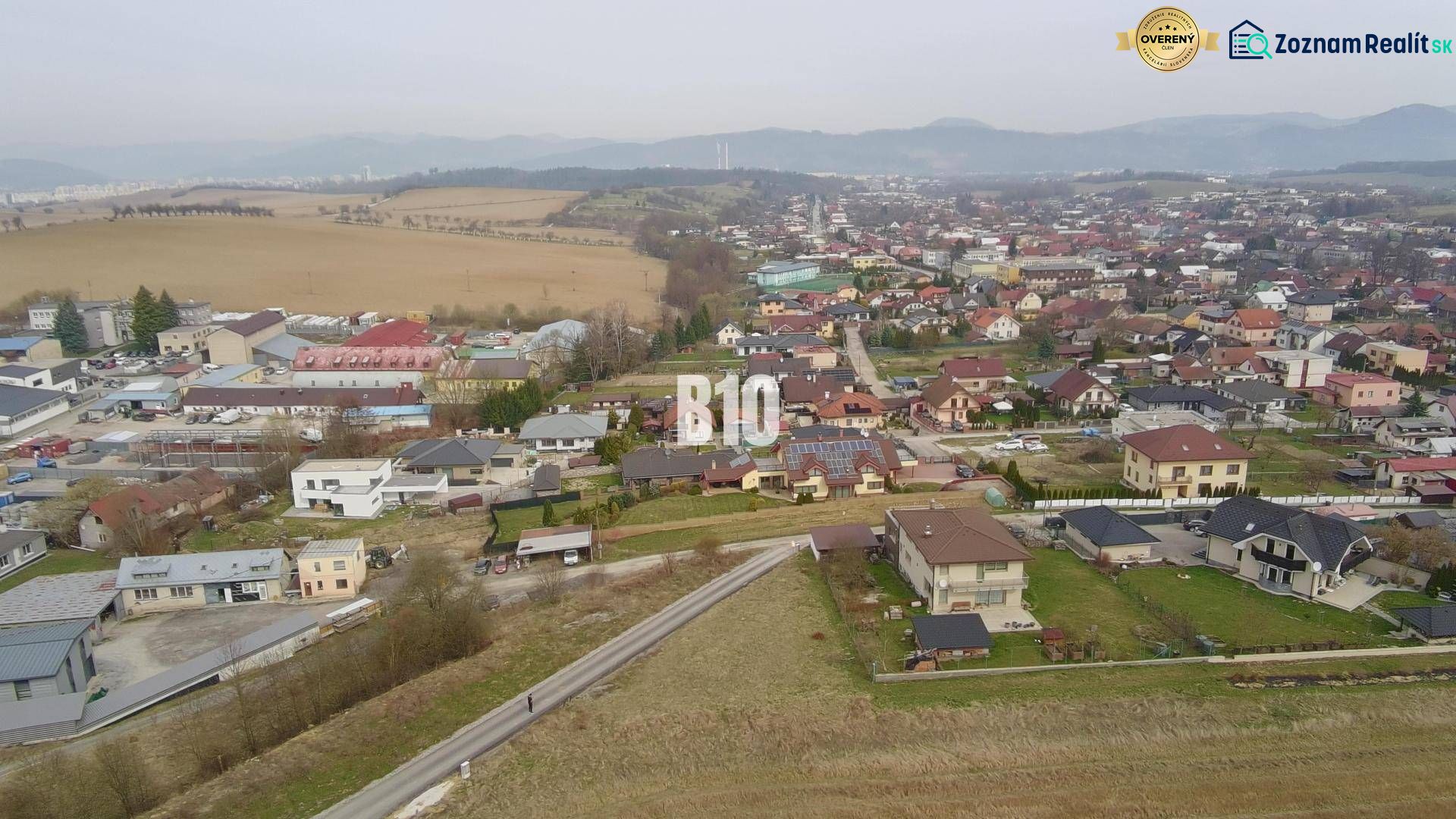 PRESTÍŽNY STAVEBNÝ POZEMOK S PROJEKTOM – ROSINA PRI ŽILINE - Letecký pohľad na obytnú oblasť v Rosine s domami a zeleňou. Pozemky - bývanie.