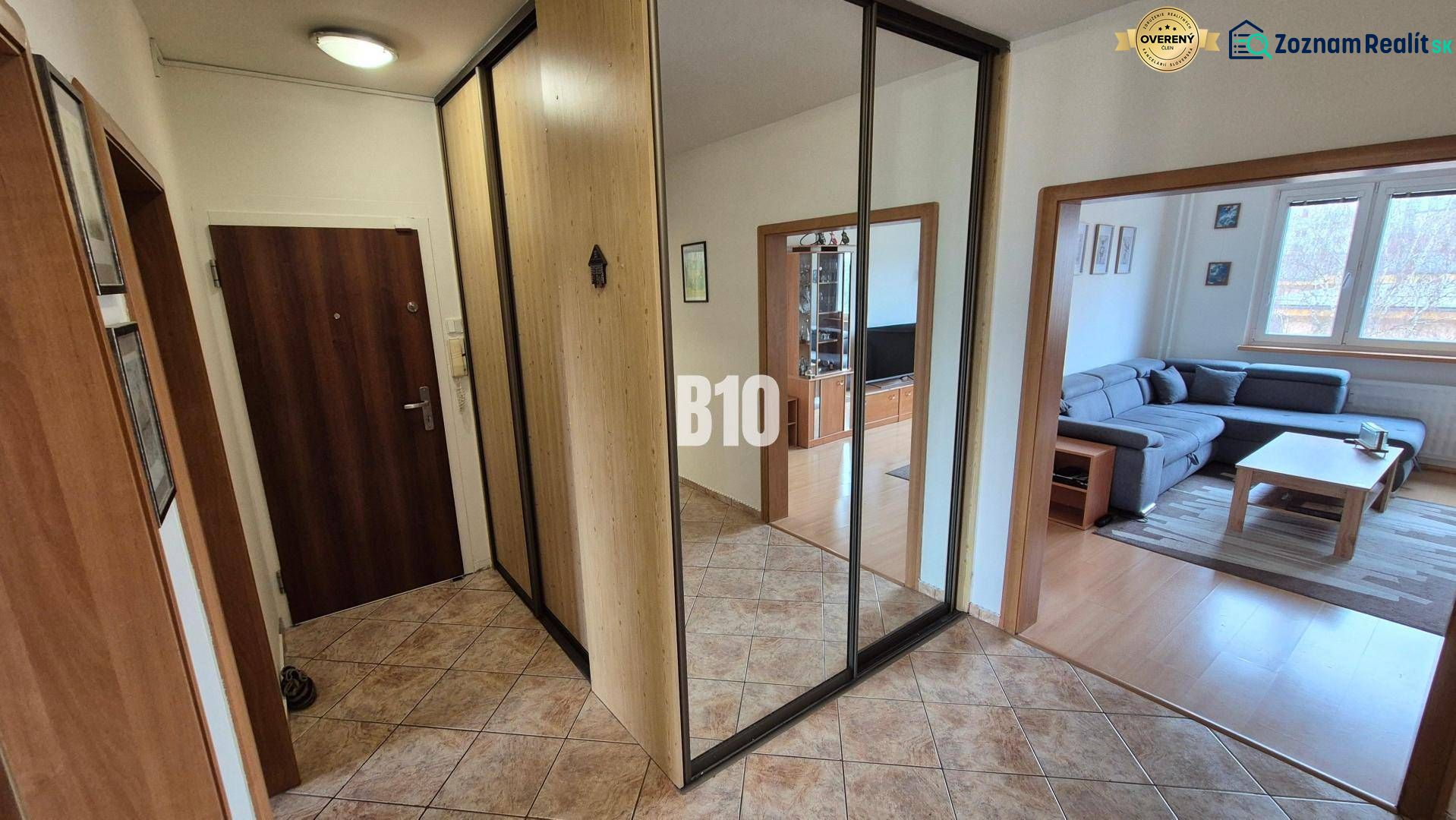 Útulný  5 izbový byt v Žiline s  balkónom - V 5 a viac izbovom byte podlahy s dreveným dekorom, zrkadlo a gauč v obývačke.