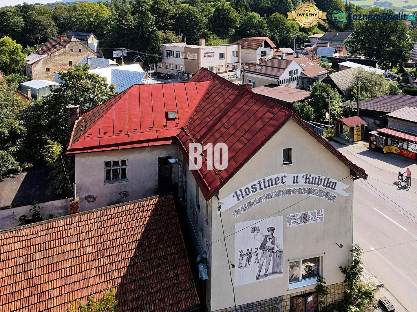 Teraz zľava 30.000 TOP INVESTIČNÁ PRÍLEŽITOSŤ Polyfunkčný objekt na pr - Hostinec v Belej s červenou strechou a nástennou maľbou muža s pivom.