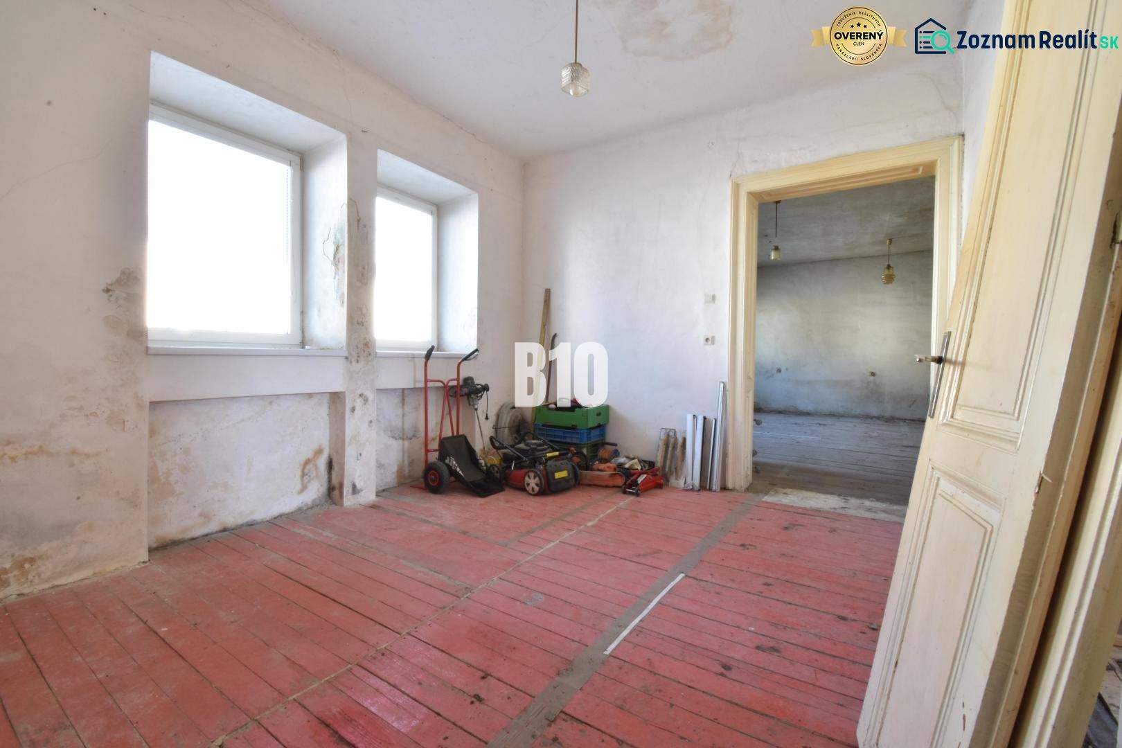 Rodinný dom na rekonštrukciu, 660m2 pozemok. - Izba v rodinnom dome s červenou podlahou a oknami, Bytča.