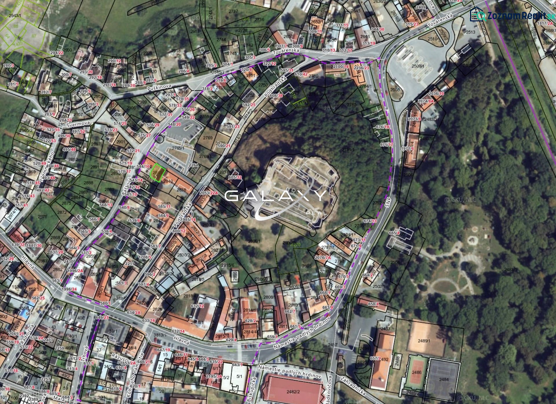 Pozemok v tesnej blízkosti hradu – Fiľakovo - Letecký pohľad na pozemky v historickom centre Fiľakova, obklopené budovami a zeleňou.