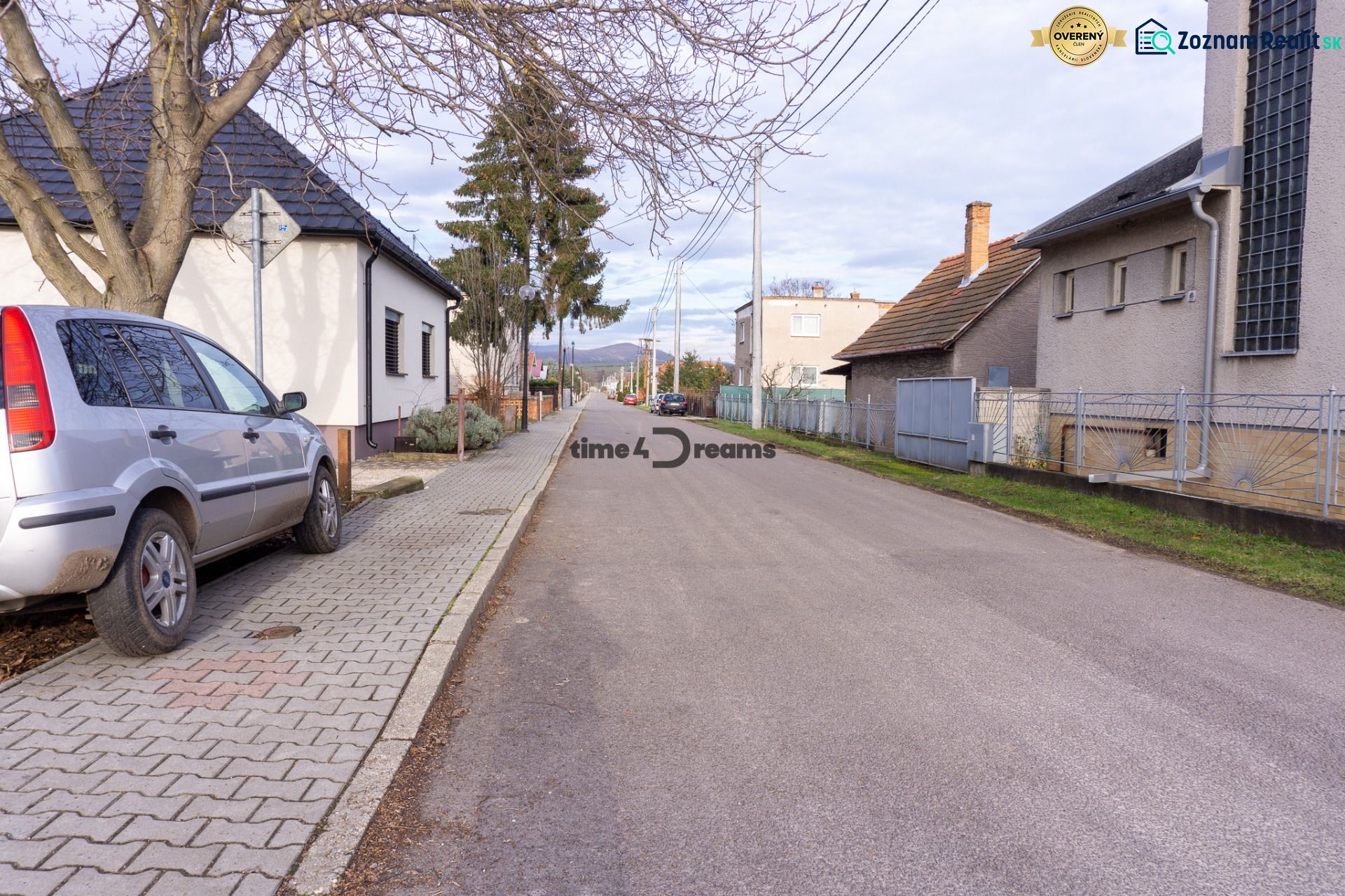 NA PREDAJ pozemky na výstavbu - Ulica s rodinnými domami na Športovej ul. a parkované auto, ideálne pre Pozemky - bývanie.