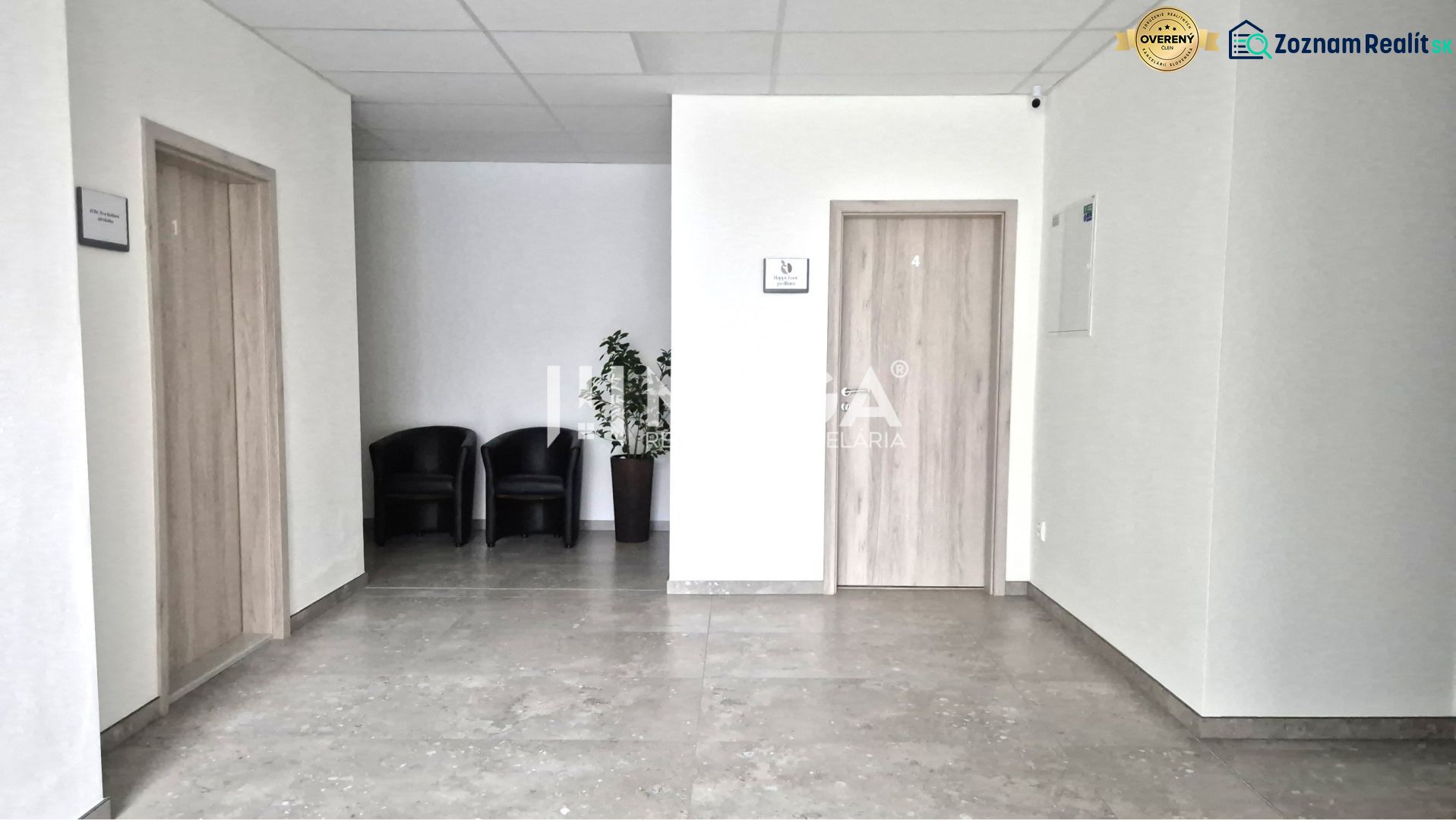PRENÁJOM komerčného priestoru (26 m2) blízko centra Humenné - Interiér obchodných priestorov s kreslami, dlažbou a dverami s dreveným dekorom.