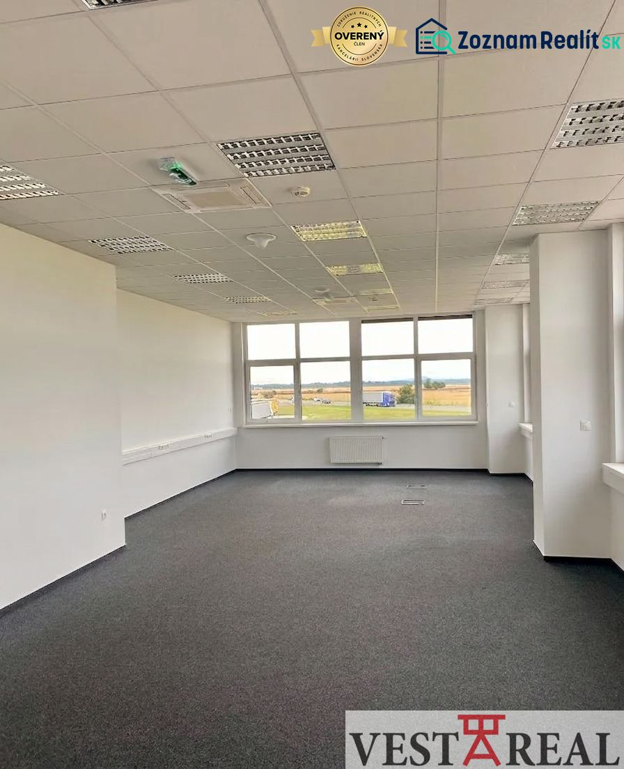 Prenájom A-Class logistickej haly s kanceláriami – 7 026 m², Galanta - Kancelárske priestory s kobercovou podlahou a veľkým oknom v budove skladov a hál.