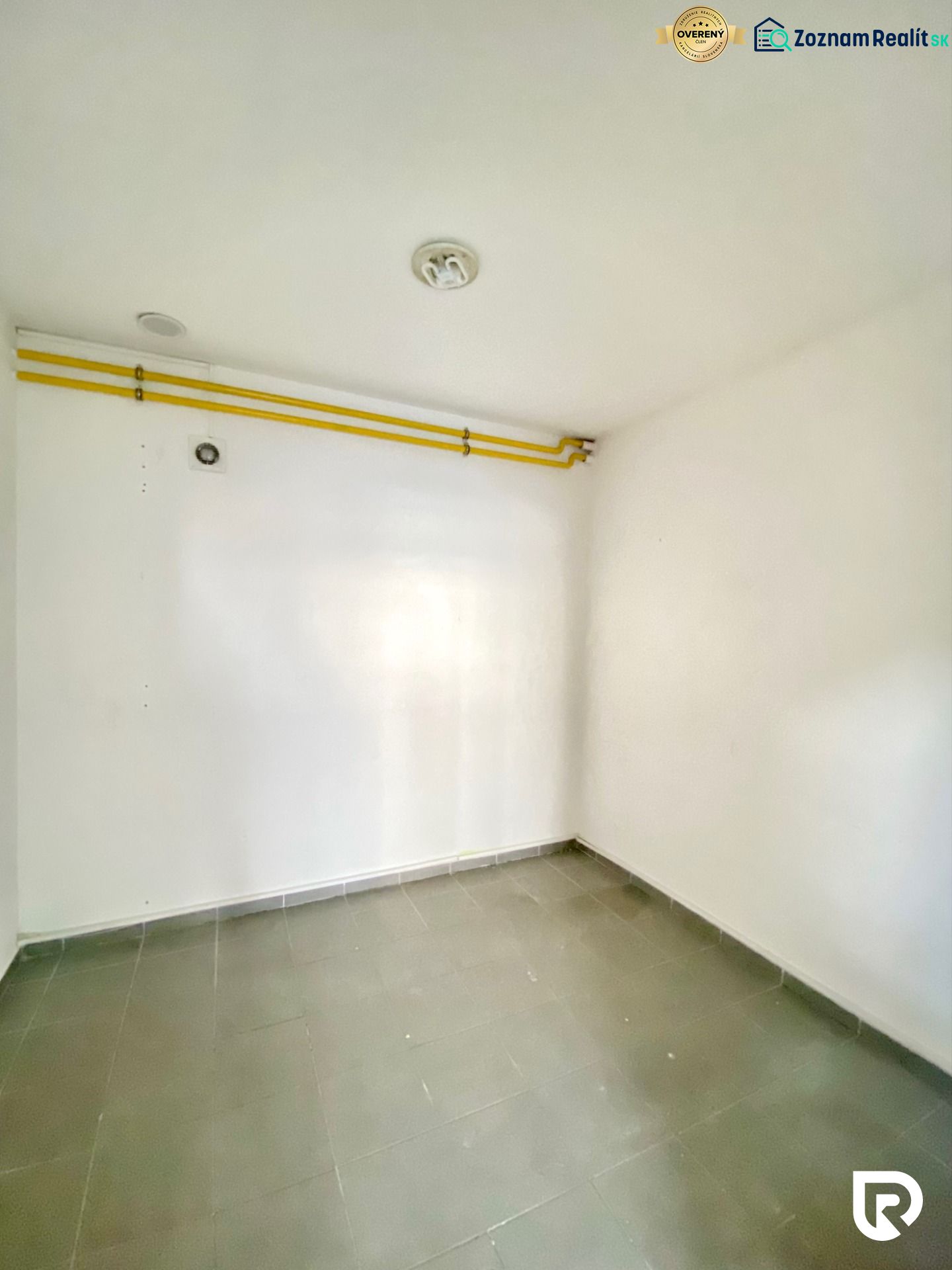 Obchodný priestor 75m2 | Zlatovská, Trenčín - Prázdna miestnosť s dlažbou, potrubím, na ulici Zlatovská vhodná pre obchodné priestory.