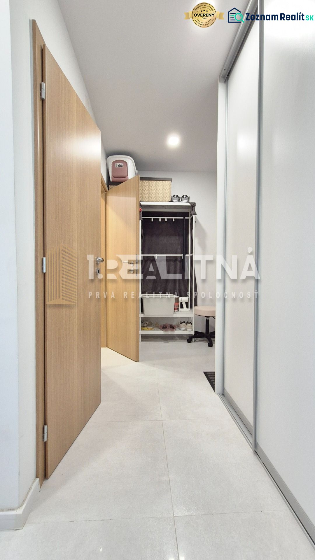 MODERNÝ DVOJIZBOVÝ BYT, 37M2, DÚBRAVKA - Chodba v 2-izbovom byte s dlažbou, vstavanými skriňami a otvorenými dverami vedúcimi k úložnemu priestoru.