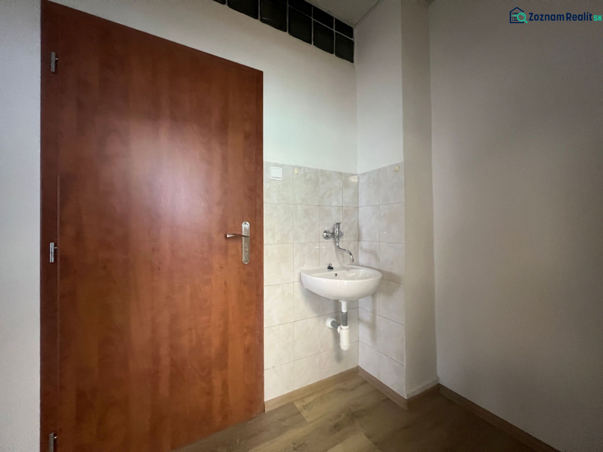 Prenájom kancelárske priestory 39,6 m² -B. Bystrica, Zvolenská cesta - Kancelárie s umývadlom, dverami a podlahou s dreveným dekorom.