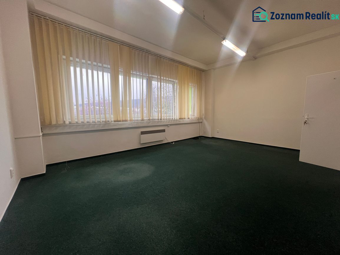 Na prenájom kancelária 24m2 - Banská Bystrica, Zvolenská cesta NO556ZL - Kancelárie s tmavým kobercom a vertikálnymi žalúziami pri veľkých oknách.