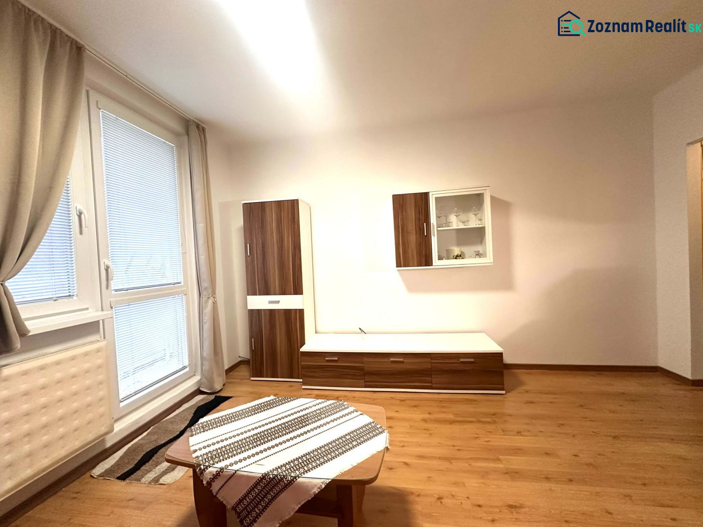 ☎️ 0918/197 701 Na prenájom garsónka s balkónom aj s výťahom   v centr - Rekreačný apartmán s podlahou s dreveným dekorom, nábytkom a veľkým oknom.