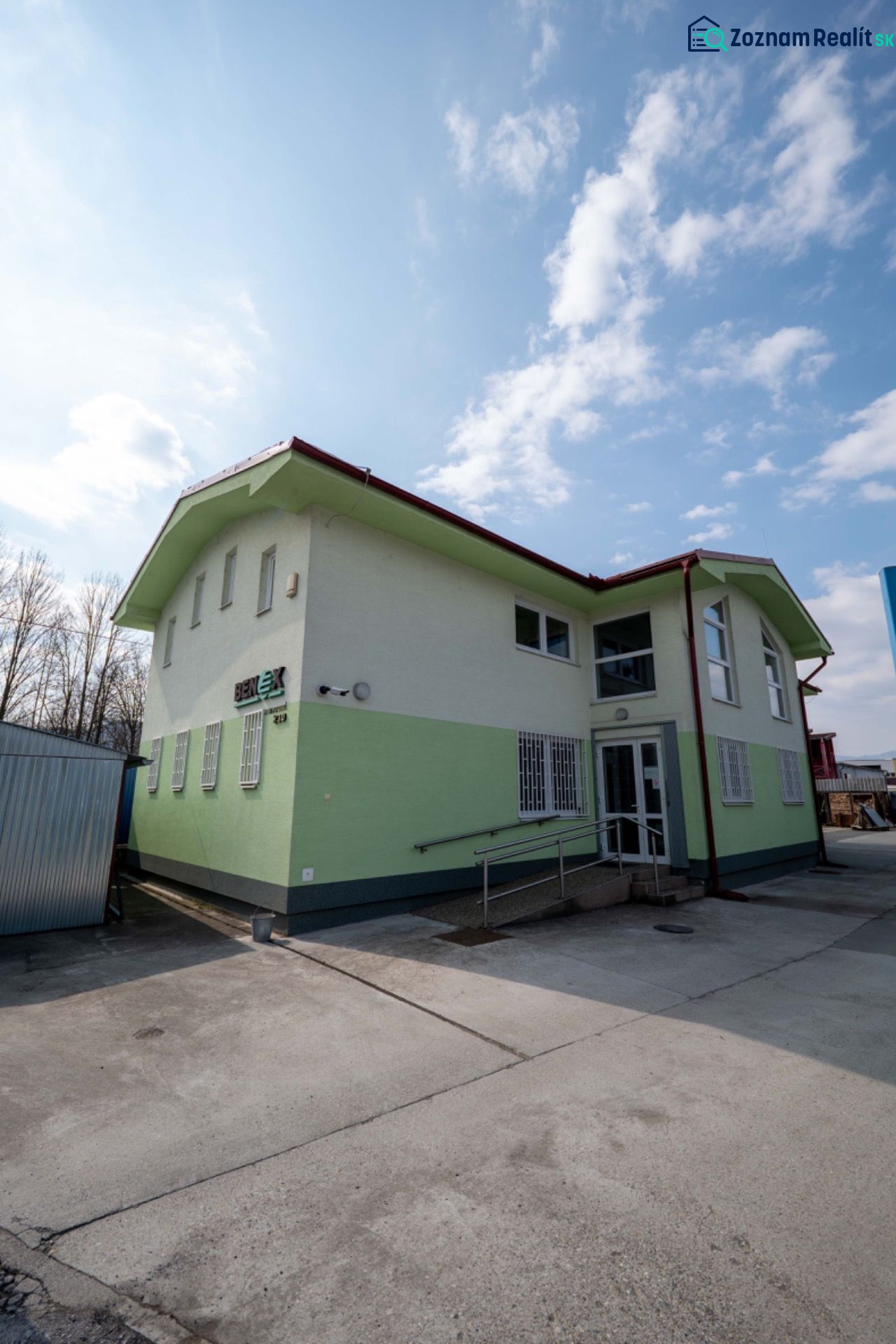 PREVÁDZKOVÝ AREÁL– HALA, ADMINISTRATÍVA, POZEMOK 1405 m² - B. Bystrica - Budova v meste Majer, Banská Bystrica s jasnou modrou oblohou. Zvláštne nehnuteľnosti.