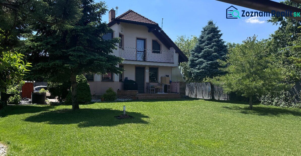 Rodinný dom v Dunajskej Lužnej  - Rodinný dom v Dunajskej Lužnej, Nové Košariská, obklopený upravenou záhradou a ihličnanmi.