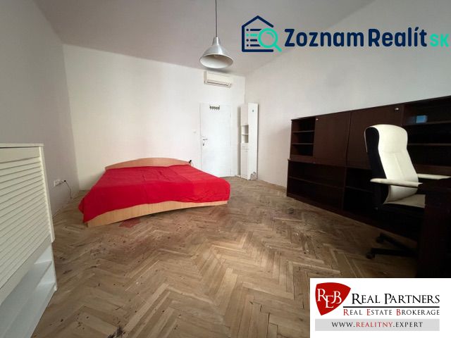 Predaj 3 izbový byt, 86 m2, Francisciho ul, Staré mesto, BAI . - Izba s posteľou, písacím stolom a podlahou s dreveným dekorom v 3-izbovom byte.