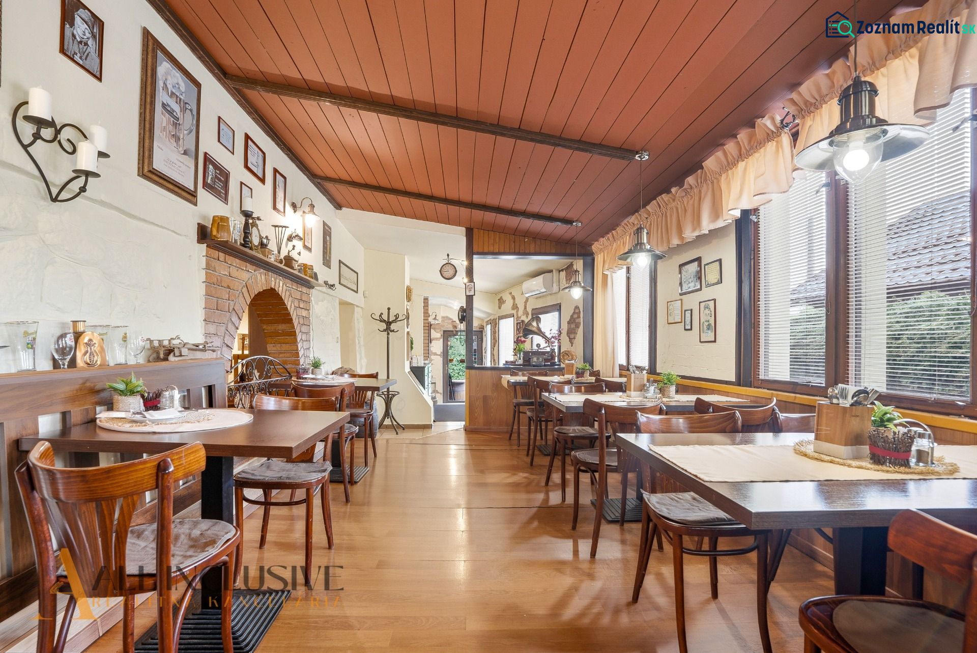 Na predaj zabehnutá reštaurácia s klientelou, Nitra - Gastro priestory s podlahou s dreveným dekorom, stolmi a dekoráciami na stenách.