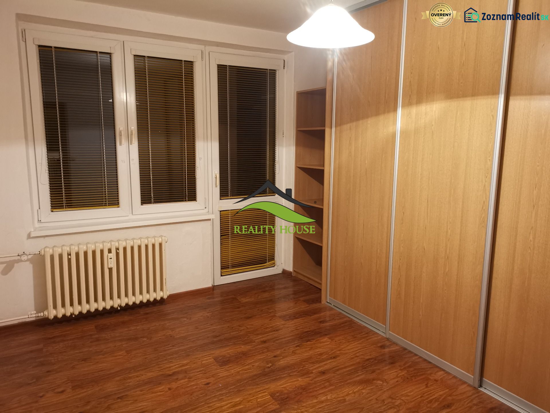 REZERVOVANÉ - Izba s podlahou s dreveným dekorom a veľkou vstavanou skriňou v 3-izbovom byte.