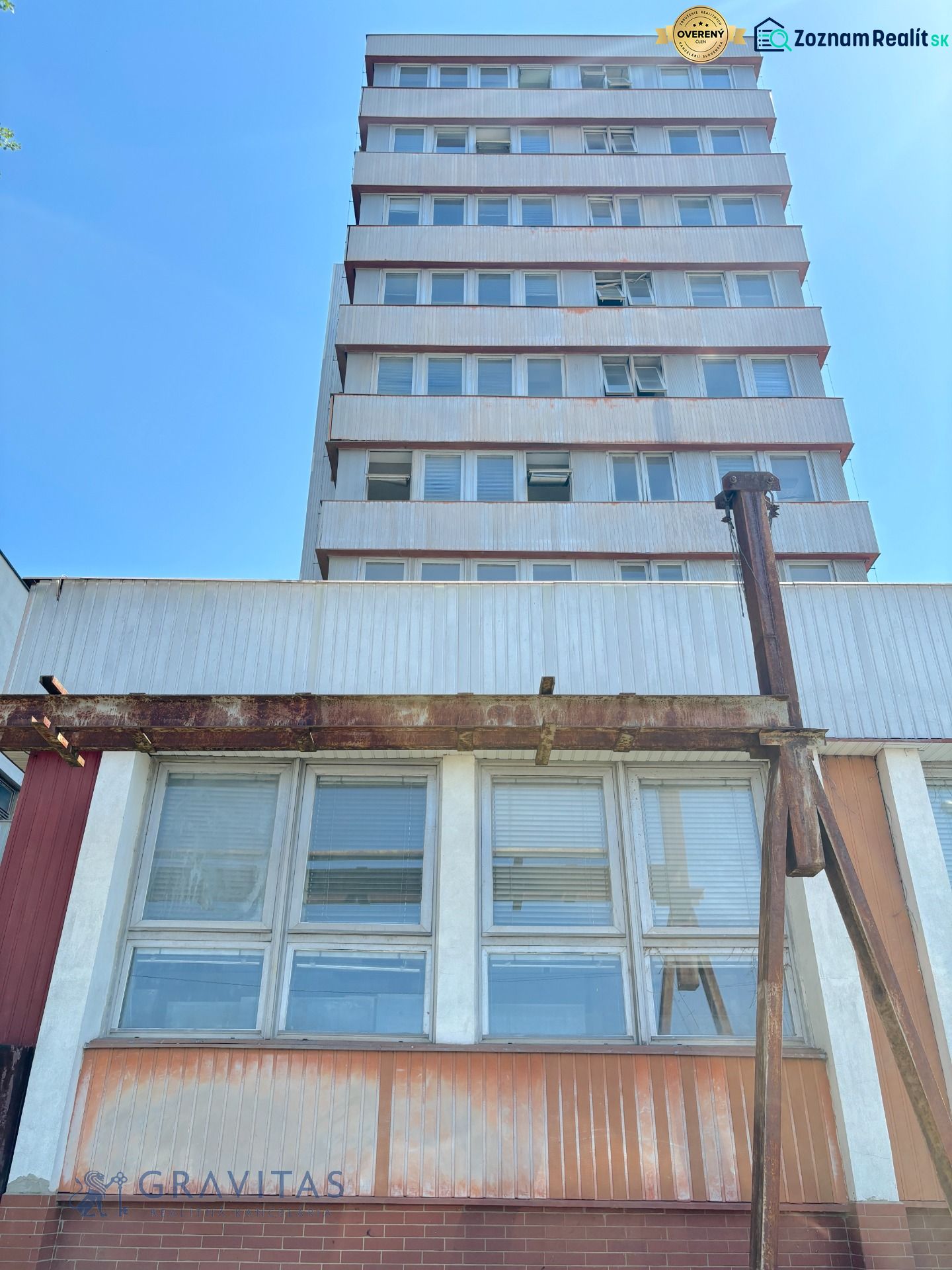 FORVIN TOWER - Predaj administratívnej budovy, Veľký Krtíš - Budova na ulici Liaz so zvláštnou nehnuteľnosťou, poschodia, okná, modrá obloha.
