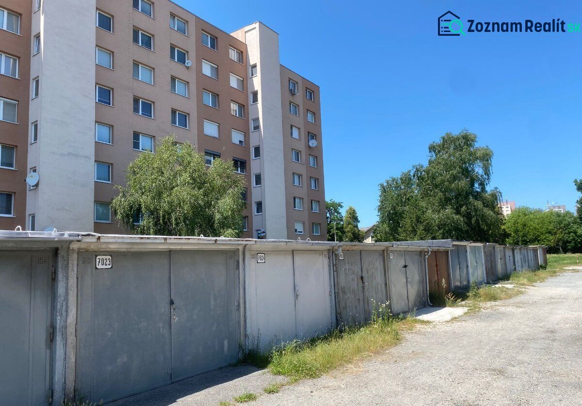 PREDAJ - Garáž v Stupave na ulici Železničná - Garáže na Železničnej ulici v Stupave, vedľa obytného domu pod modrou oblohou.