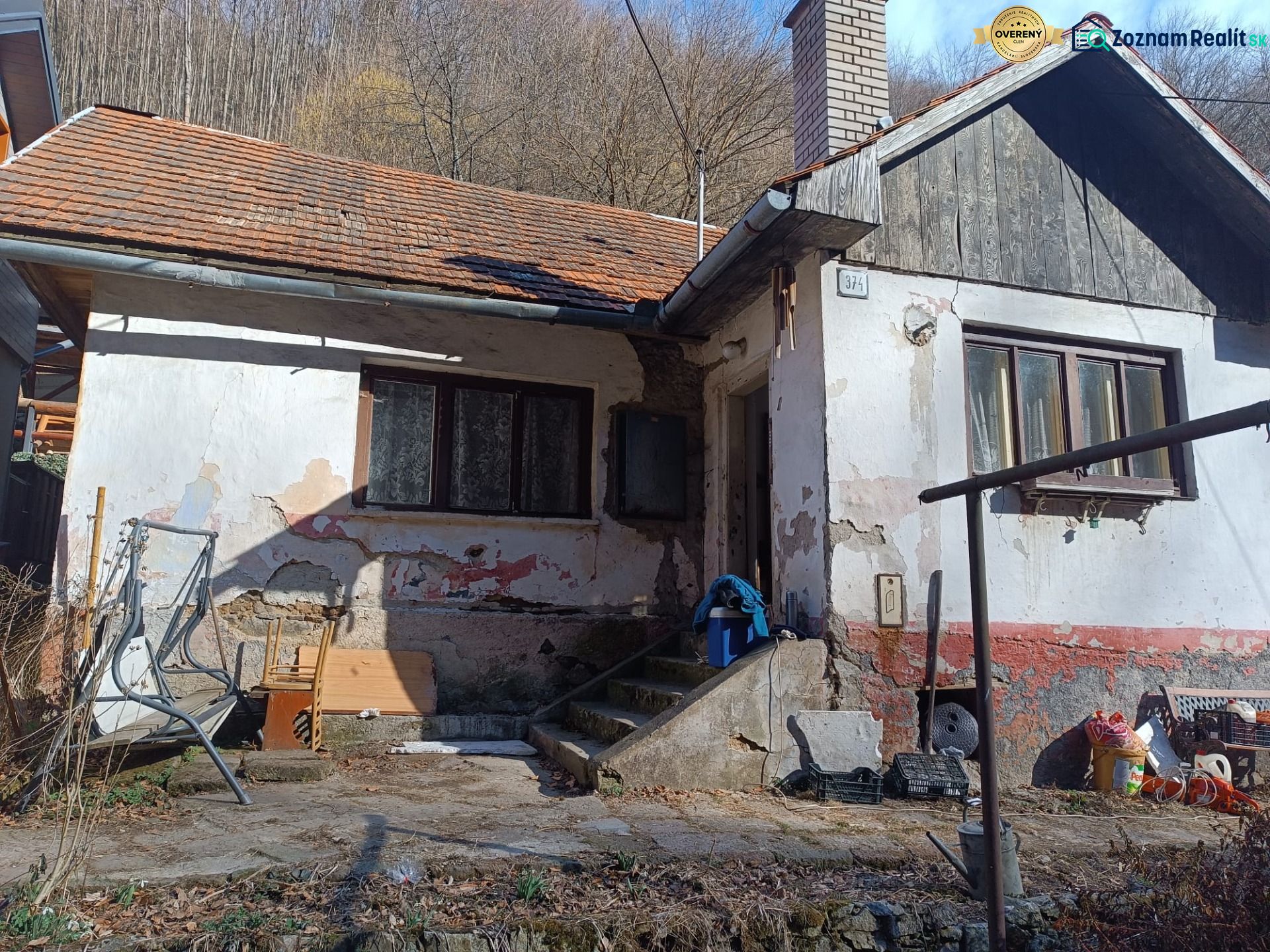 Na predaj chalupa  Banská Hodruša v tichej lokalite - Na obrázku je starší rodinný dom na ulici Banská Hodruša s vyrastenou trávou.