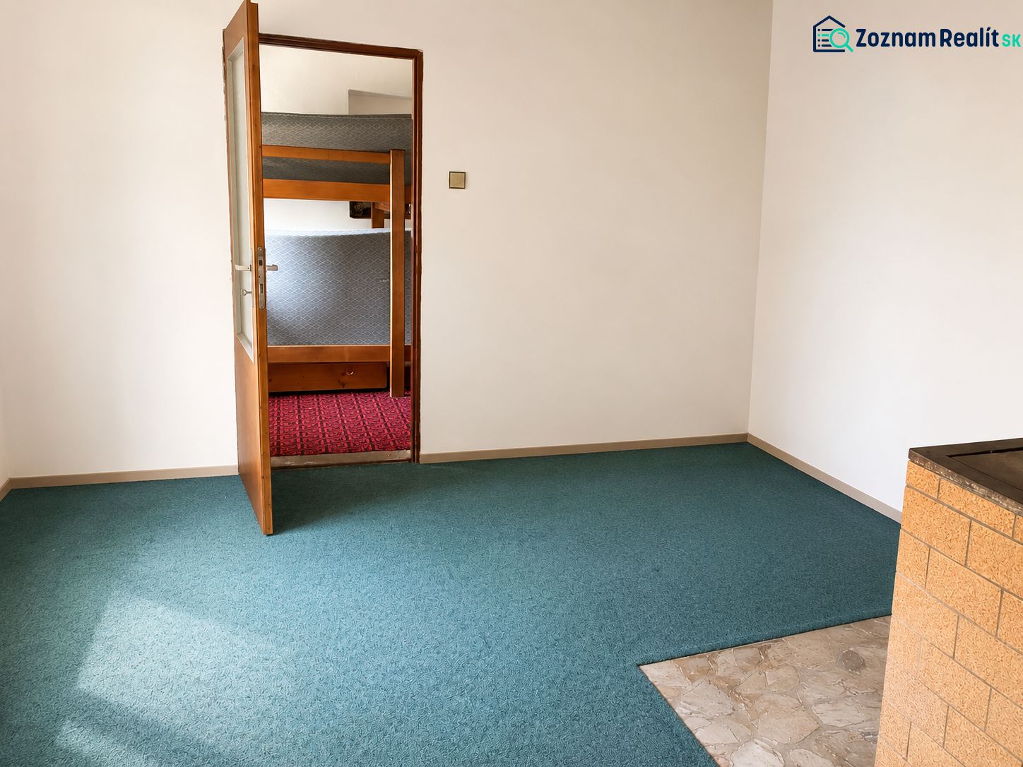 Menší Rodinný dom Veľké Košecké Podhradie, pozemok 340 m2 - Interiér Rodinného domu s otvorenými dverami a kobercom modrej farby.